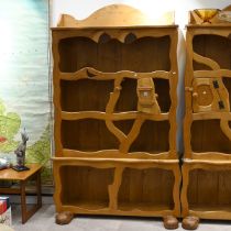 A late 20th Century character oak bookcase, with carved eyes and booted feet. H 197cm, W 112cm, D...