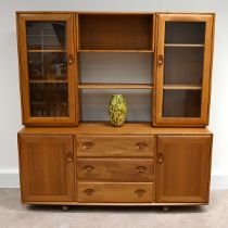 Mid Century Ercol light elm bookcase, comprising central shelved bookcase flanked by glazed and s...