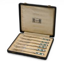 An Arts & Crafts set of six silver and enamelled Medea pastry forks, the finials cast in relief w...