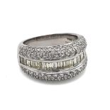 An 18k white gold and diamond ring, eighteen baguette cut diamonds, flanked by ninety-eight round...