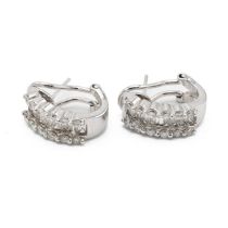 A pair of 14ct white gold and diamond hoop earrings, each earring set with seven baguette diamond...