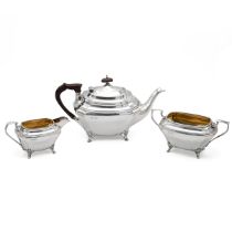 A George V silver three piece silver tea set, with outstretched feet and a gilded interior, 1063 ...