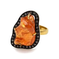 An 18k yellow gold garnet and diamond ring, set with a free-form shaped orange garnet 15.86cts, w...
