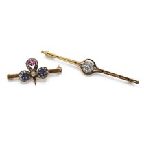 A 9ct yellow gold bar brooch, applied with a fleur-de-lis set with ruby, sapphires, diamonds and ...