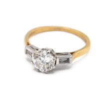 An 18ct gold and platinum diamond ring, the central brilliant cut stone weighing approximately 1....