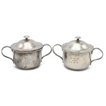 A pair of Edwardian matching silver hammered bowls and covers, each with loop handles and knob fi...