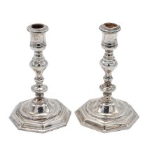 A pair of Elizabeth II silver cast candlesticks, in the 18th century style and standing on octago...