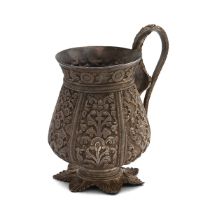 A 20th century Indian silver mug, with a curved cobra handle, standing on a seven point base and ...