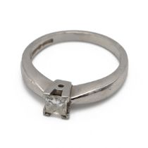 An 18ct white gold and diamond ring, in a four claw setting, the princess cut stone weighing appr...