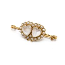 A Victorian yellow gold moonstone and seed pearl bar brooch, set with two heart shaped cabochon m...