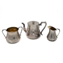 A Victorian silver three piece tea set, each piece with engraved trailing flowers and plants thro...