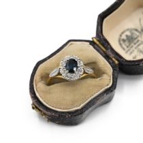 An 18ct gold and sapphire cluster ring, the oval sapphire surround by brilliant cut diamonds, fin...