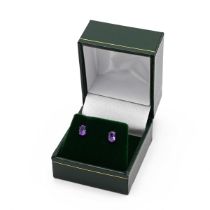 A pair of 18k white gold and amethyst oval stud earrings, claw set with oval mixed cut stones, po...