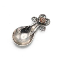 A George V silver and enamel caddy spoon, with a hammered fig-shaped bowl, the tapering handle te...