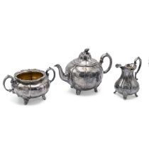 A Victorian silver three piece tea set, with engraved flowers and plants throughout, standing on ...