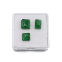 Three loose faceted emeralds, including two square and one rectangular cut stones. J