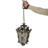 A brass and glass early to mid 20th century ceiling lantern housing a single bulb the glass with ...