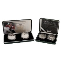 Two (2) silver proof Crown coin sets from The Royal Mint in their original presentation boxes. In...