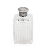 Cut glass cologne flask with silver screw top of square form with diamond cut pattern. H 9.5cm.