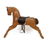 Mid 20th Century carved pine rocking horse, lacking rocking base, with leather saddle and stirrup...