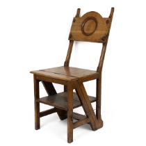 A late 19th/early 20th century light oak Gothic metamorphic library steps chair, the panelled bac...