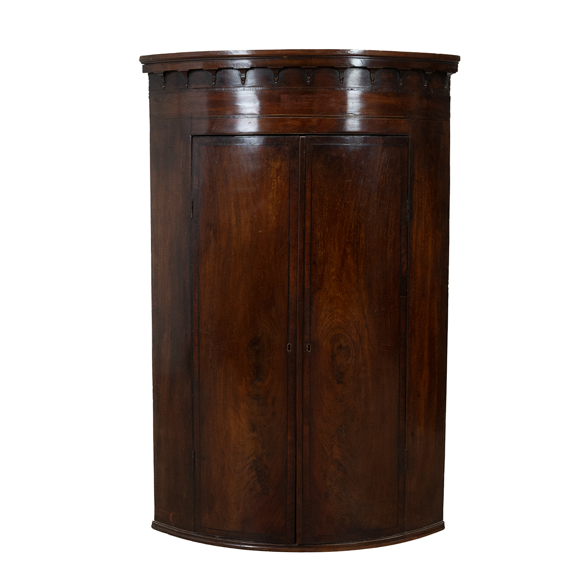 Georgian mahogany bow fronted corner cupboard with ebony and boxwood stringing, castellated pedim...