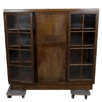 1930's oak cabinet comprising central drop down door opening to reveal a cocktail cabinet over a ...