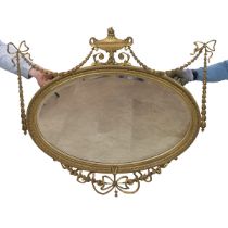 Regency Adams style oval mirror, with bevelled glass, the gilt wooden frame decorated with gilt b...