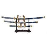 Set of three graduated in size decorative Katana on  wooden stand. Longest sword approx 102cm, sh...