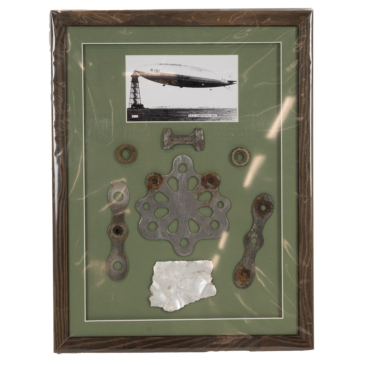 Aviation interest. Framed rare parts dug from the crash site of the R101 Airship c1930. Parts inc...