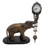 Mystery Clock by Junghans, in the form of a cast metal elephant, its raised trunk supporting the ...