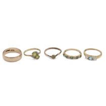 A peridot and diamond crossover ring, the two peridots between diamond set shoulders, in a 9 cara...