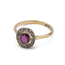 An Edwardian ruby and diamond cluster ring, the oval cut stone enclosed by old single cut diamond...
