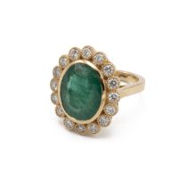 An emerald and diamond cluster ring, the large oval cut measuring approximately 15 by 12 by 6.6mm...