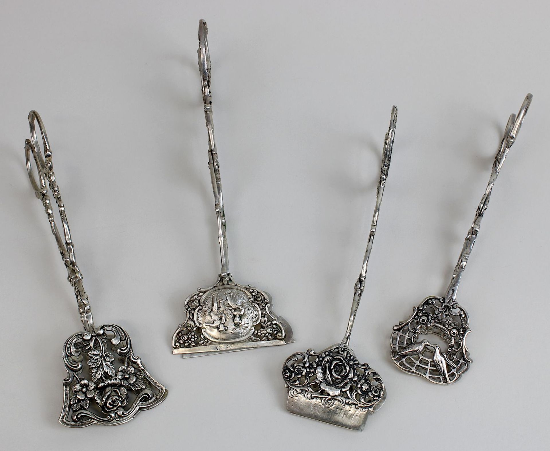 Vier Gebäckzangen 800er (3 Stück) und 835er Silber, deutsch 1. H. bis M. 20. Jh., eine Handarbeit