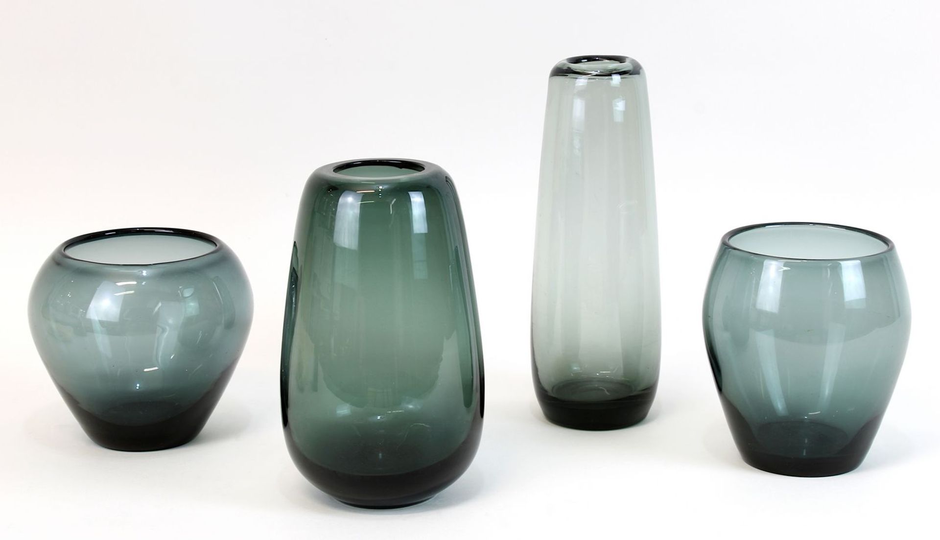 Vier Glasvasen, Entwurf Wilhelm Wagenfeld 1950, Glaskörper aus grau-grünem Glas, H 13, 15, 21 u.