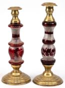 2 Biedermeier-Leuchter, gegliederter Hohlschaft aus Glas z.T. rot lasiert, gefüllter Stand und Tüll