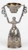 Brautbecher, Silber (geprüft), in Form einer Frau im bodenlangen, reliefierten Kleid, in den erhobe