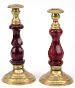 2 Biedermeier-Leuchter, gegliederter und facettiert geschliffener Hohlschaft aus rotem Glas, gefüll