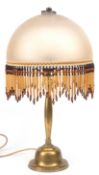 Tischlampe, 1. Hälfte 20. Jh., Messing-Fuß, halbrunder Schirm mit Behang aus Glas-Perlen und -Röhrc