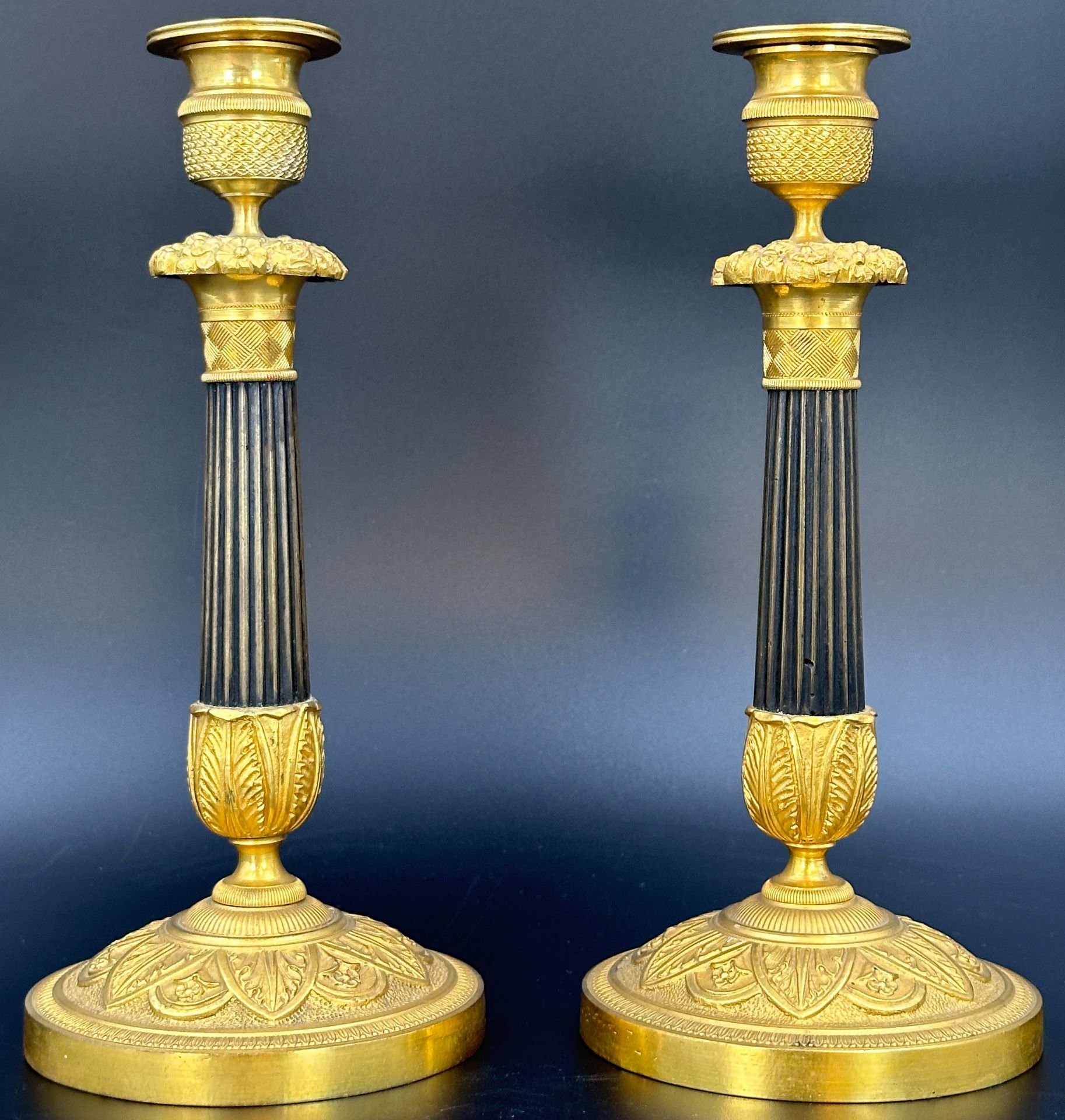 A pair of richly decorated Empire candlesticks. France. 19th century.