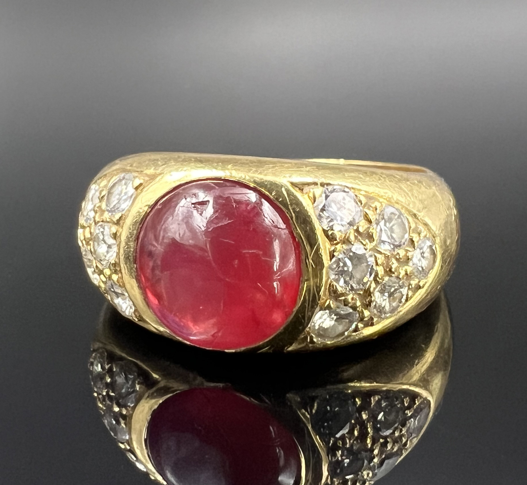 Ladies' ring. 750 yellow gold with diamonds and a red coloured stone cabochon.