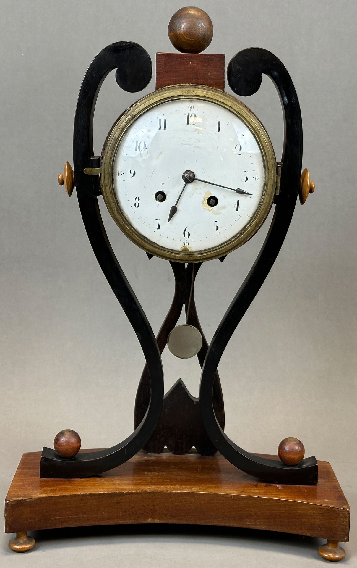 Antique mantel clock with striking mechanism and enamelled dial. 1st half of the 19th century.