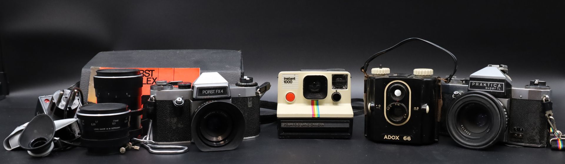 4-piece convolute of cameras with lenses.