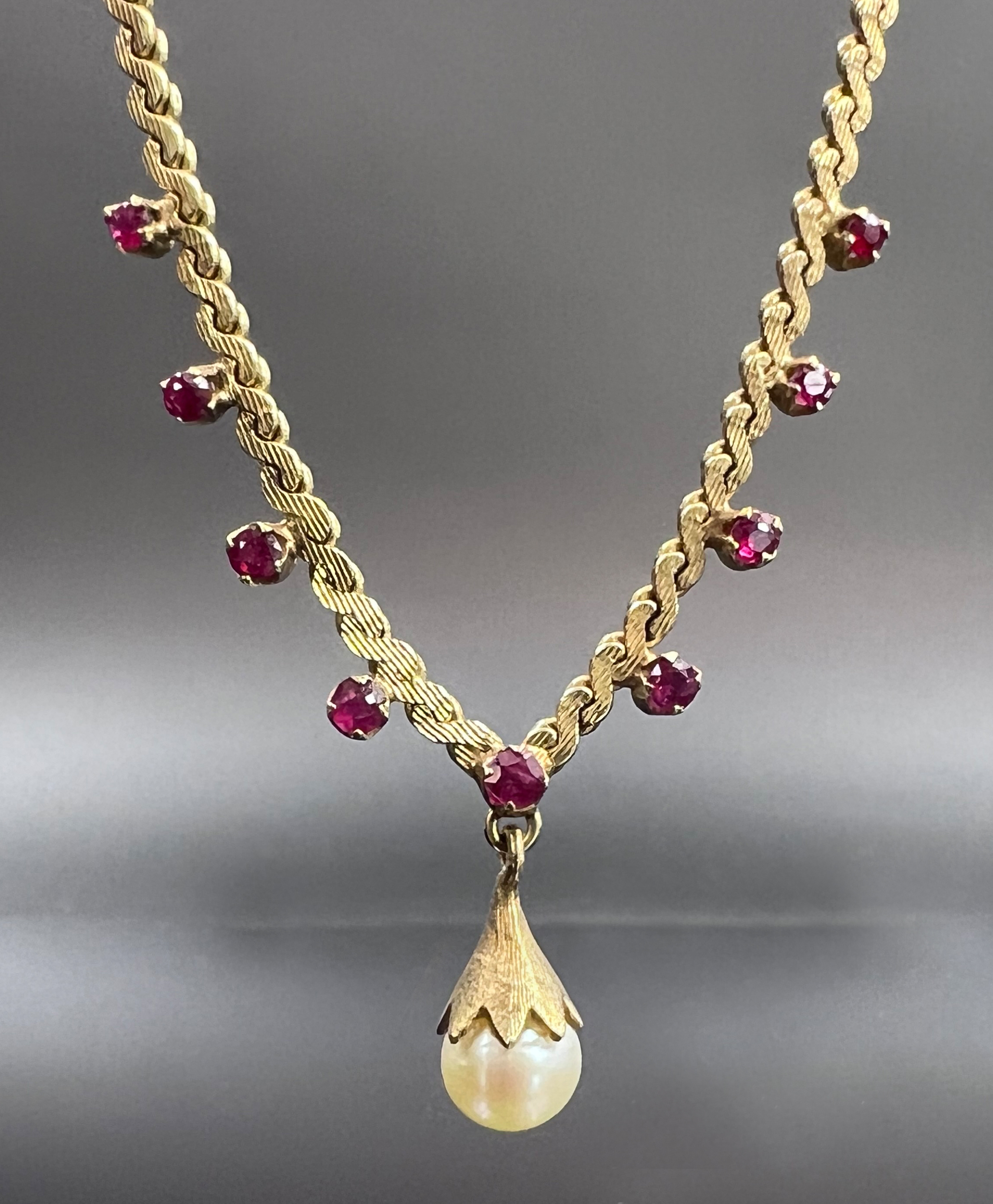 Necklace. 585 yellow gold with 9 small rubies and a pearl.