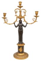 French Empire, A pair of patinated brass and ormolu figural candlesticks