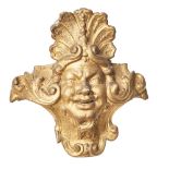 British, Early 18th Century, A carved giltwood mask furniture element