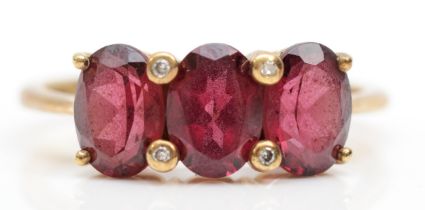 A 9ct gold three stone garnet dress ring, O, 2.5gm.