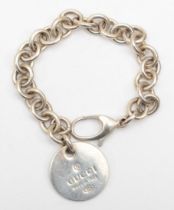 Gucci, a silver identity bracelet with round tag, 19cm, 32gm.