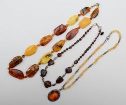 An amber free form beaded necklace with silver clasp, 61cm, together with a silver relief carved